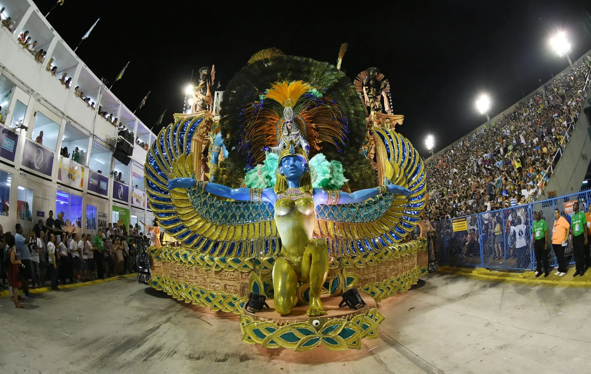 A Sambadrome box before the first parade — empty glasses, stage light in the distance